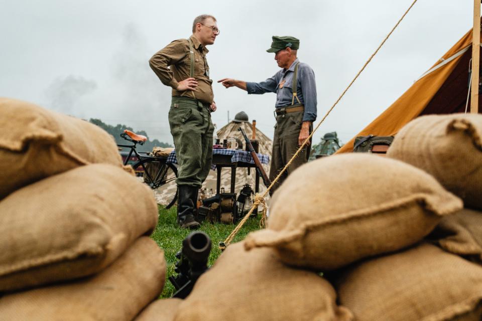 WWII re-enactors Eric Eddy, left, and Bob Penix, right, converse, Friday, Sept. 8 during the annual Steam to Victory event at the Age of Steam Roundhouse Museum in Sugarcreek.