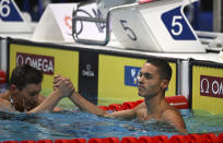 David Popovici of Romania, right, celebrates after winning the Men 100m Freestyle final at the 19th FINA World Championships in Budapest, Hungary, Wednesday, June 22, 2022. (AP Photo/Anna Szilagyi)