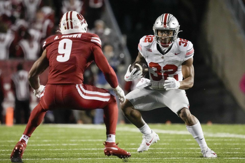 Ohio State's TreVeyon Henderson (32) runs with Wisconsin's Austin Brown (9) defending during the first half of an NCAA college football game Saturday, Oct. 28, 2023, in Madison, Wis. (AP Photo/Morry Gash)