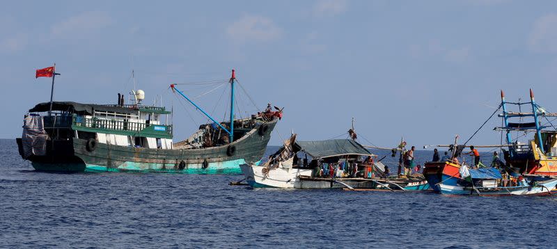 FILE PHOTO: A Chinese fishing vessel is anchored next to Filipino fishing boats at the disputed Scarborough Shoal