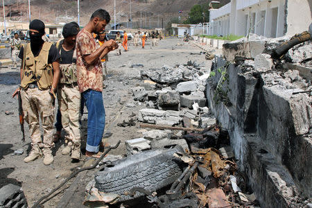 Security personnel inspect the site of a car bomb attack outside the headquarters of a counter-terrorism unit in Aden, Yemen February 25, 2018. REUTERS/Fawaz Salman