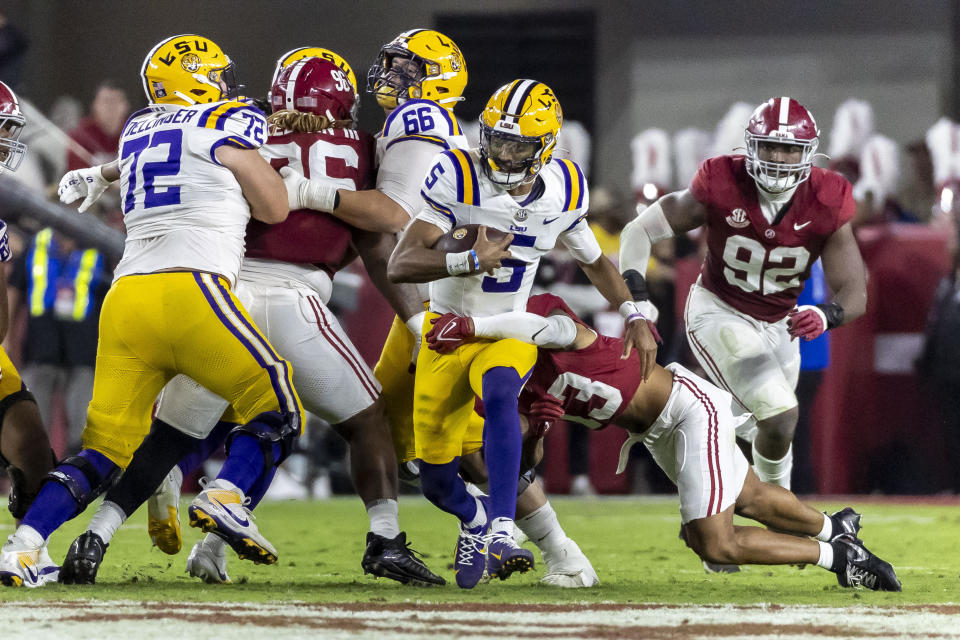 LSU quarterback Jayden Daniels (5) runs the ball as Alabama defensive back Malachi Moore (13) tackles during the first half of an NCAA college football game, Saturday, Nov. 4, 2023, in Tuscaloosa, Ala. (AP Photo/Vasha Hunt)