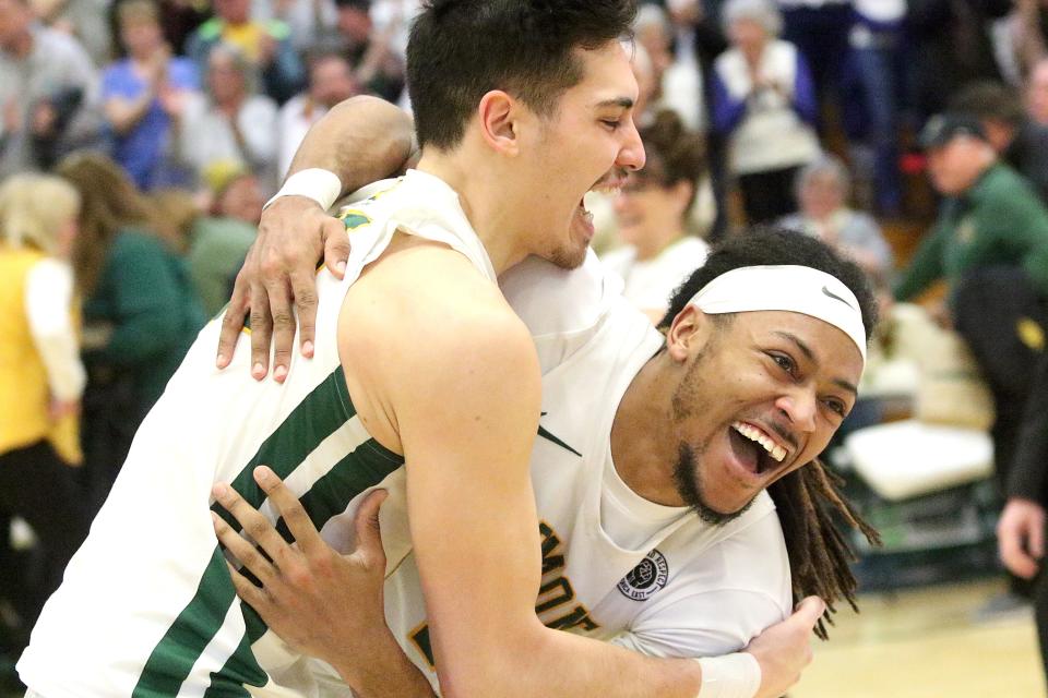 Vermont's Robin Duncan (left) and Dylan Penn hug in celebration after the final horn sounded in the Catamounts 72-59 win over UMass Lowell in the America East title game on Saturday afternoon at Patrick Gym.