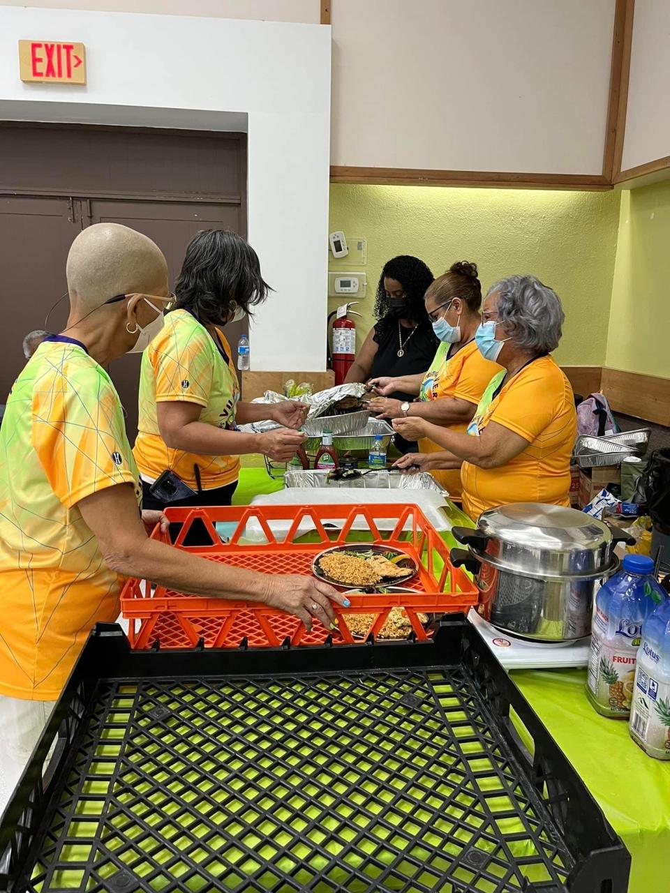 A group of volunteers with Vieques En Rescate, which supports cancer patients in Vieques, Puerto Rico, put together food. The group honors their patients during a festival fundraiser once a year.