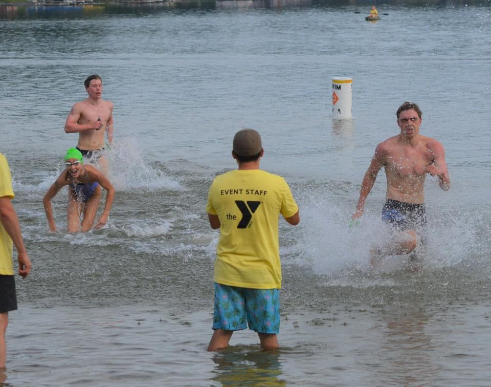 Harper Creek senior Justin LaFleur, right, gets to his feet first to start running to the finish line ahead of second-place Lillian Mahar to win the 95th annual Goguac Lake Swim on Saturday.