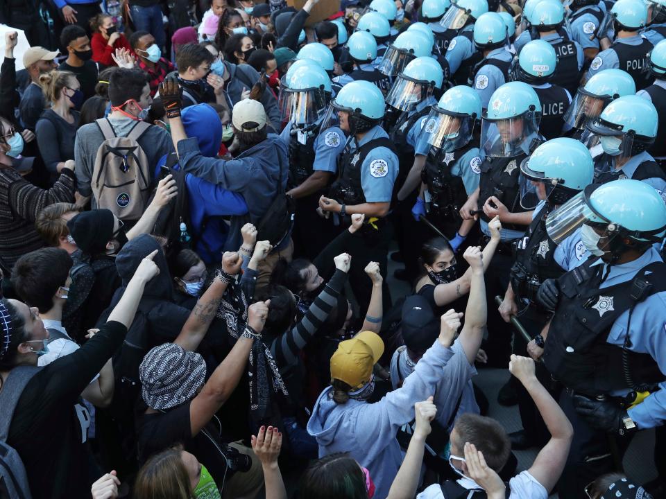 In this Saturday, May 30, 2020 photo, police officers guard the Trump International Hotel & Tower in Chicago, as they hold back protesters during a rally and march over the death of George Floyd. Protests were held in U.S. cities over the death of Floyd, a black man who died after being restrained by Minneapolis police officers on May 25.  (John J. Kim/Chicago Tribune via AP)