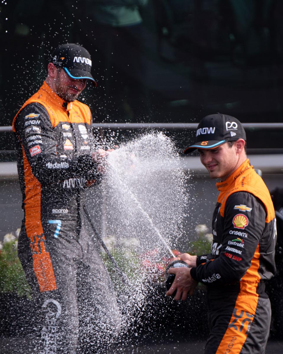 Arrow McLaren SP driver Pato O'Ward (5) and Arrow McLaren SP driver Alexander Rossi (7) spray champagne on one another Saturday, May 13, 2023, during the celebration of the GMR Grand Prix at Indianapolis Motor Speedway. 