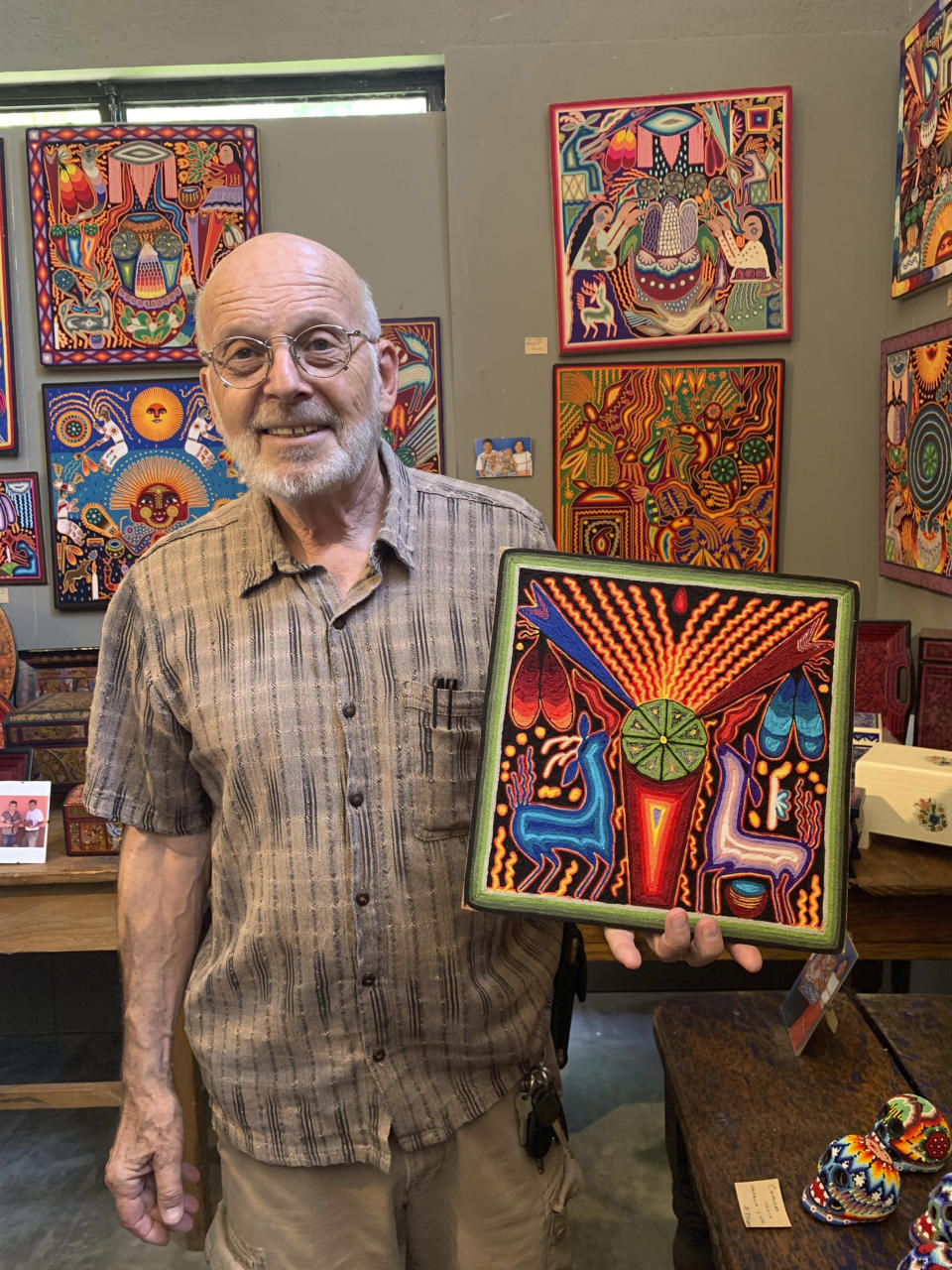 Mayer Shackter muestra un cuadro de los huichol en su Galería Atotonilco de San Miguel de Allende, México, el 17 de junio del 2019. (Emil Varona/Kim Curtis via AP)