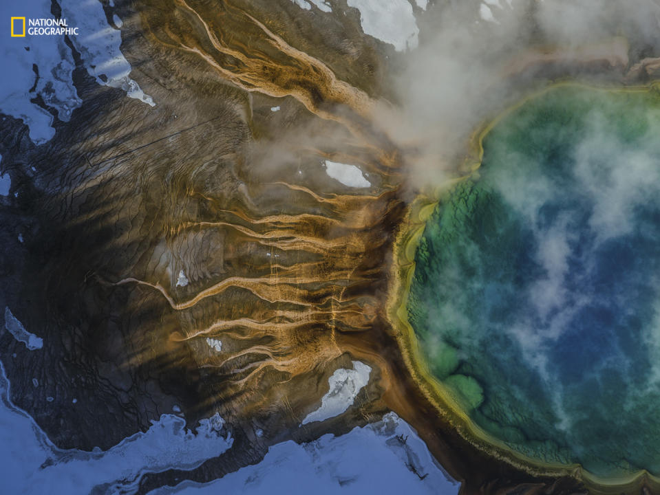 <p>The Grand Prismatic Spring in Yellowstone National Park smokes and glows, as pictures form above. (Michael Nichols) </p>