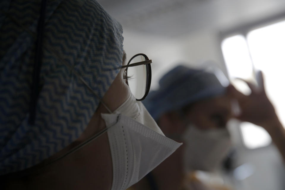 Nurses watch screen near rooms with patients affected by COVID-19 virus in the ICU unit at the Charles Nicolle public hospital, Thursday, April 15, 2021 in Rouen, France. A renewed crush of COVID-19 cases is again forcing intensive care units across France to grapple with the macabre mathematics of how to make space for thousands of critically ill patients (AP Photo/Christophe Ena)