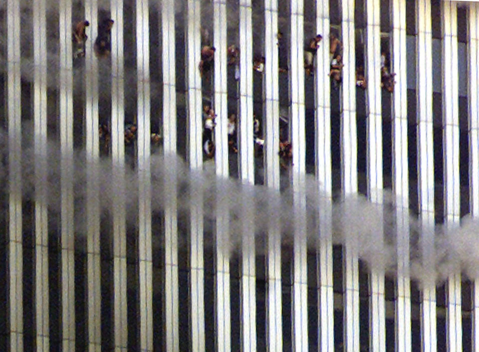 Varias personas se asoman por las ventanas de la torre norte mientras que el edificio está en llamas.<br><br>Foto: REUTERS/Jeff Christensen