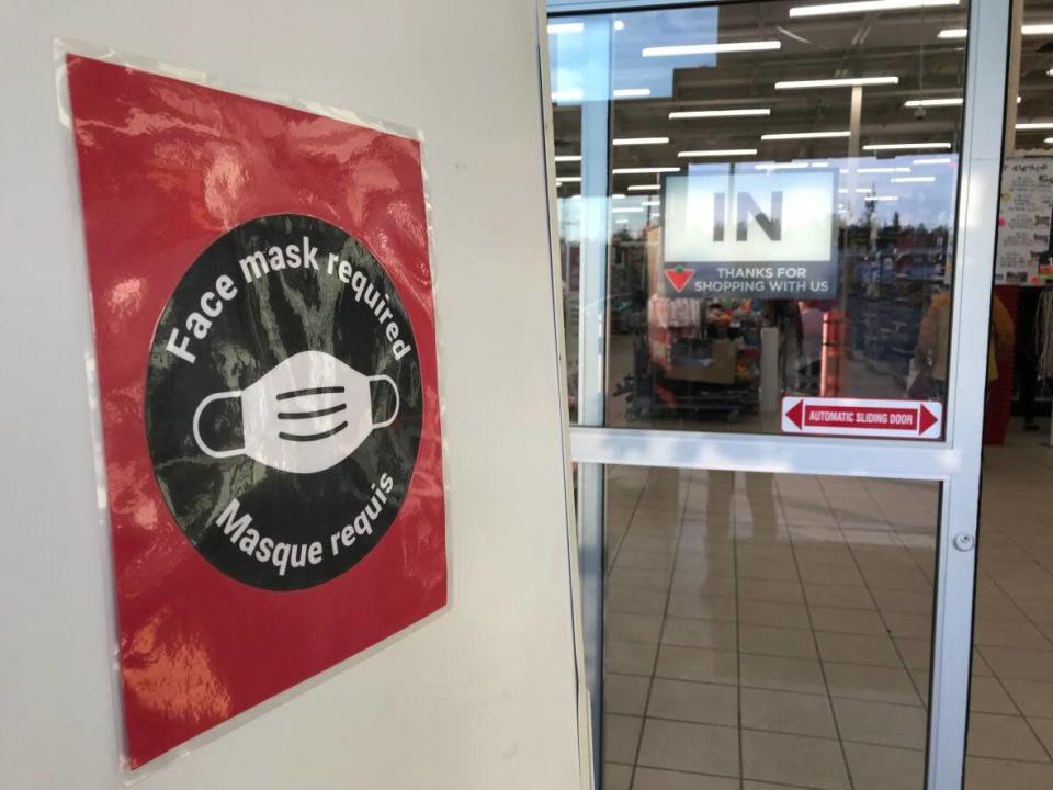 A sign stating masks are required inside Canadian Tire in Yellowknife on August 30, 2021. The N.W.T. government has issued exposure notices for a number of Yellowknife businesses in the last few days, including Canadian Tire.  (Liny Lamberink/CBC - image credit)