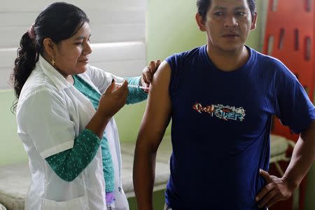 A nurse applies a vaccine for an Influenza virus to Rufino Raymonde, a Machiguenga indigenous man, in a health post at Diamante, a town near the Alto Madre de Dios River, May 26, 2014. REUTERS/Enrique Castro-Mendivil