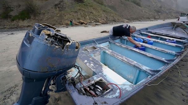 PHOTO: Boat salvager Robert Butler picks up a canister in one of one of two boats sitting on Blacks Beach, March 12, 2023, in San Diego. (Gregory Bull/AP)