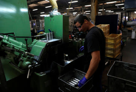 A worker holds a component for a Volvo truck at the Muller manufacturing facility in Redditch, Britain August 28, 2018. Picture taken August 28, 2018. REUTERS/Darren Staples