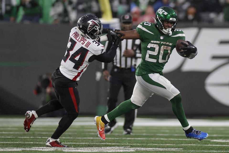 New York Jets running back Breece Hall (20) carries the ball against Atlanta Falcons cornerback Clark Phillips III (34) during the fourth quarter of an NFL football game, Sunday, Dec. 3, 2023, in East Rutherford, N.J. (AP Photo/Adam Hunger)