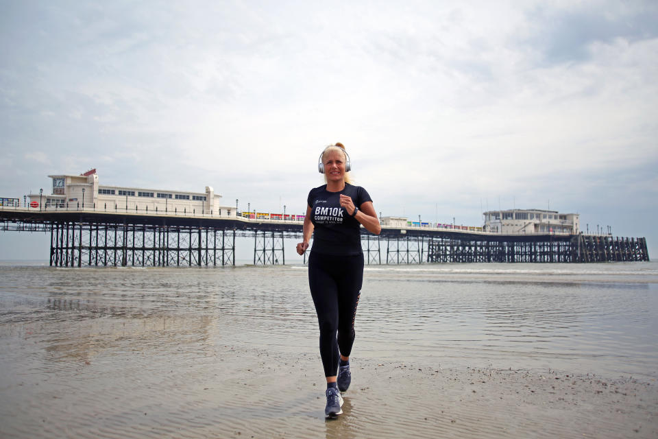 A woman runs alone on Worthing beach in front of Worthing Pier to get her daily exercise and obey social distancing instructions as the UK continues in lockdown to help curb the spread of the coronavirus.