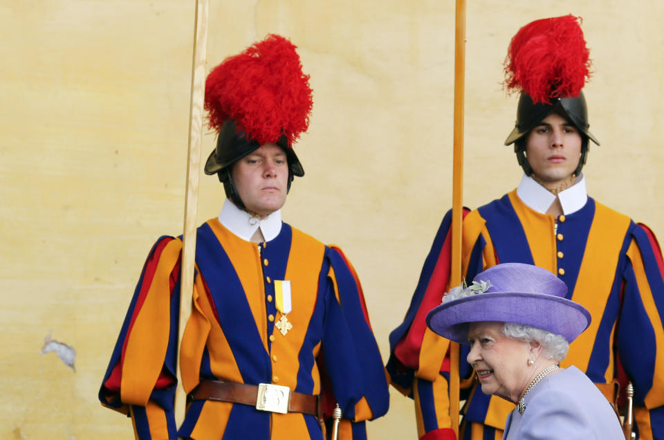 Swiss guards stand to attention as Britain's Queen Elizabeth arrives to meet Pope Francis for a meeting at the Vatican April 3, 2014. Queen Elizabeth II has come to Rome for lunch with Italy's president Giorgio Napolitano ahead of the British monarch's first meeting with Pope Francis. Before Francis, Elizabeth had met with four pontiffs, starting with Pope Pius XII in 1951, a year before her accession to the throne. (AP Photo/Stefano Rellandini, Pool)