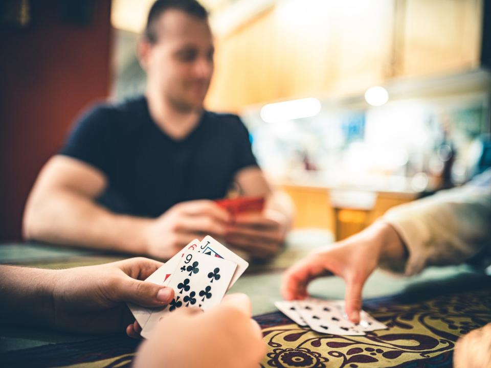 Jóvenes jugando al póker en una mesa de un bar