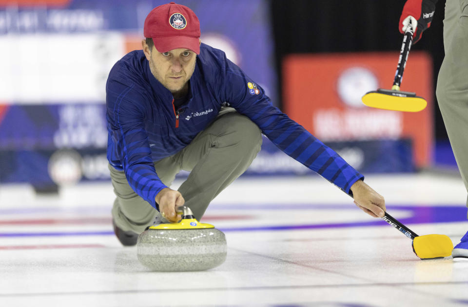 FILE - Team Shuster's John Shuster slides the stone while competing against Team Dropkin at the U.S. Olympic Curling Team Trials at Baxter Arena in Omaha, Neb., Wednesday, Nov. 17, 2021. The five-time Olympian is back to defend his curling gold medal in Beijing, and the target on his back will be almost as big as the one on the ice. (AP Photo/Rebecca S. Gratz, File)