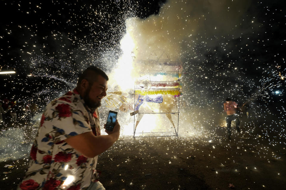 Residents attend the nighttime lighting of giant paper-mache "toritos" or bulls stuffed with fireworks during the annual festival honoring Saint John of God, in Tultepec, Mexico, Friday, March 8, 2024. The celebration, now its 35th year, pays homage to the patron saint of the poor and sick, St. John of God, who the fireworks' producers view as a protective figure. (AP Photo/Marco Ugarte)