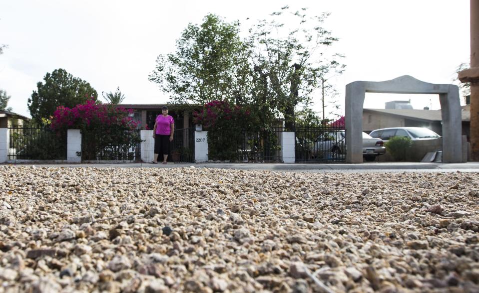 Emma Cordova stands near Sherman Parkway in her South Phoenix neighborhood, where temperatures are often hotter than other nearby areas.