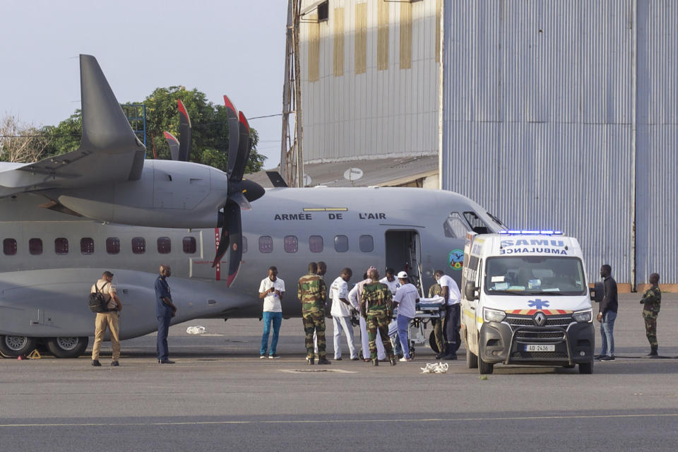 Airport personnel transfer a survivor of a deadly migration attempt into an ambulance at a military base in Dakar, Senegal, Monday, Aug. 21, 2023. A few dozen survivors were repatriated from Cape Verde to Senegal and reunited with their families, a week after they were found adrift in the Atlantic, as they tried to reach Spain's Canary Islands. (AP Photo/Zane Irwin)