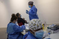 Madrid Emergency Service (SUMMA) health workers conduct rapid antigen tests for COVID-19 in the southern neighbourhood of Vallecas in Madrid, Spain, Tuesday, Sept. 29, 2020. Madrid has a rate of infection 2.5 times higher than the national average, which is already three times the European average, including the UK. (AP Photo/Bernat Armangue)