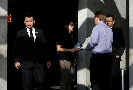 A security employee (L) looks on as a recruiter from Tesla (C) talks to a job seeker at the hotel where the electric vehicle maker is holding a recruiting event for its California factory, in the municipality of San Pedro Garza, neighbouring Monterrey, May 5, 2017. REUTERS/Daniel Becerril