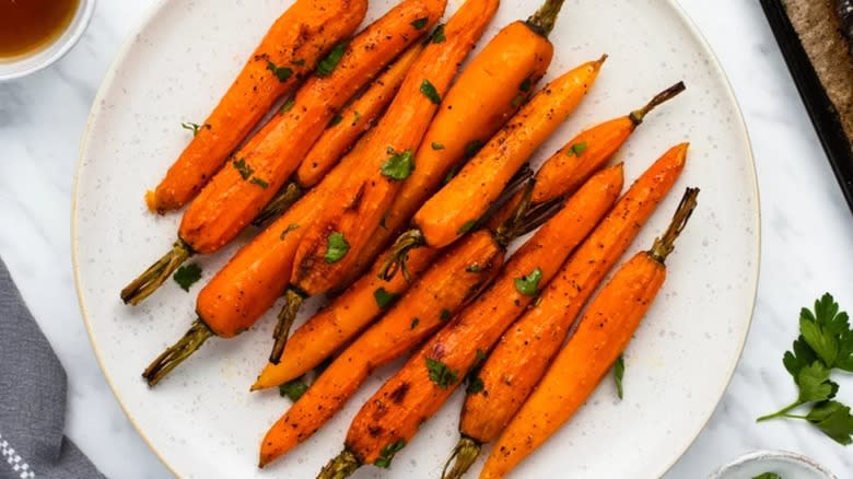 Plate of roasted carrots on white tablecloth