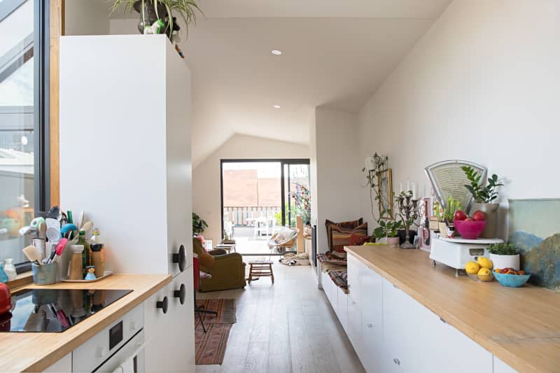 galley kitchen with wood counter tops and white cabinets