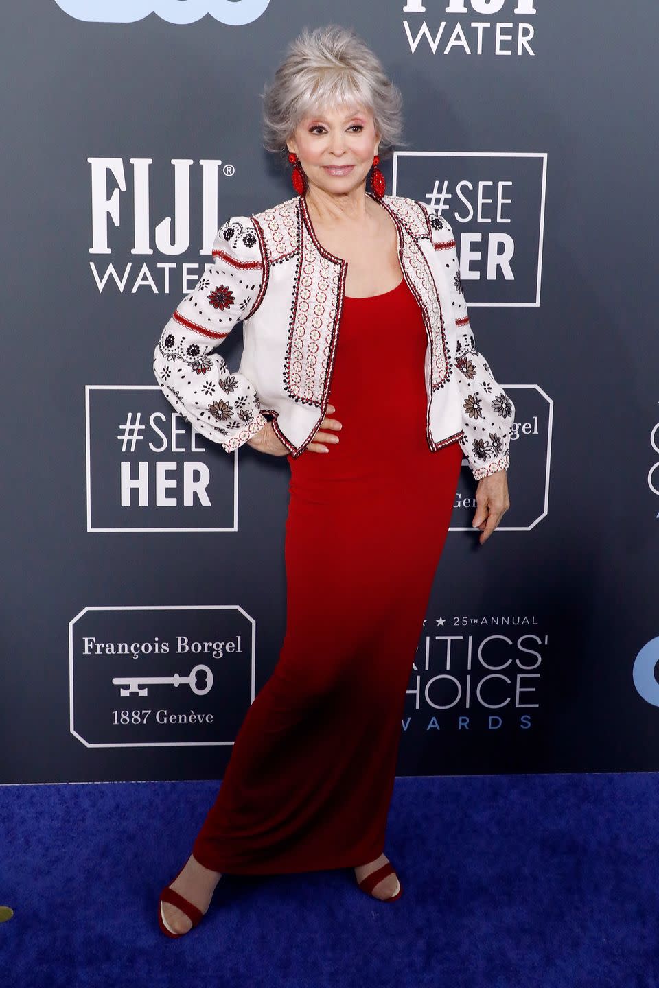 <p>Rita Moreno matches her red dress with her accessories.</p>