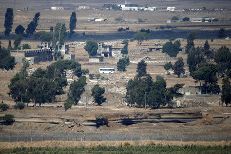 A bus drives on a road near Quneitra at the Syrian side of the Israeli Syrian border as it is seen from the Israeli-occupied Golan Heights, Israel July 21, 2018. REUTERS/Ronen Zvulun