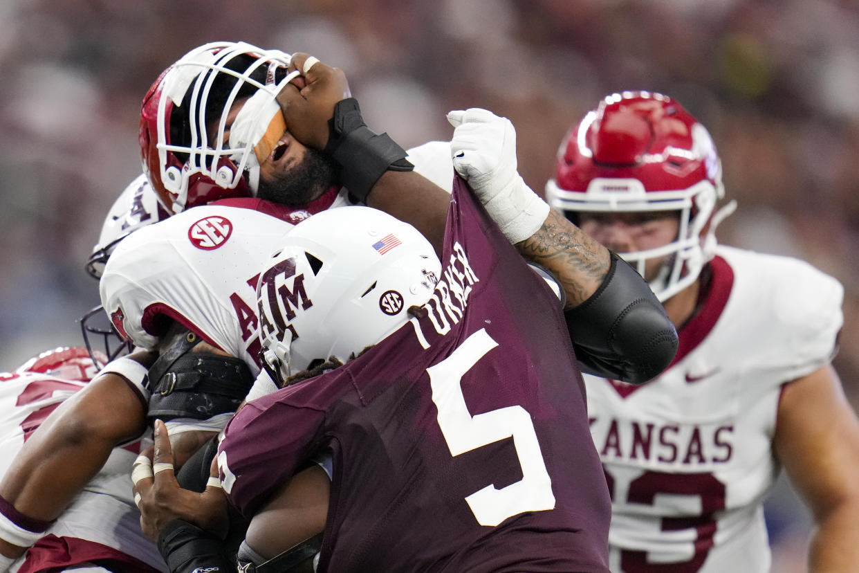 Texas A&M defensive lineman Shemar Turner's hand is seen on the face of Arkansas offensive lineman Keyshawn Blackstock while rushing in during the first half of an NCAA college football game, Saturday, Sept. 28, 2024, in Arlington, Texas. (AP Photo/Julio Cortez)