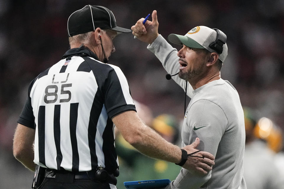 Line judge Daniel Gallagher (85) speaks with Green Bay Packers head coach Matt LaFleur during the second half of an NFL football game against the Atlanta Falcons, Sunday, Sept. 17, 2023, in Atlanta. (AP Photo/Brynn Anderson)