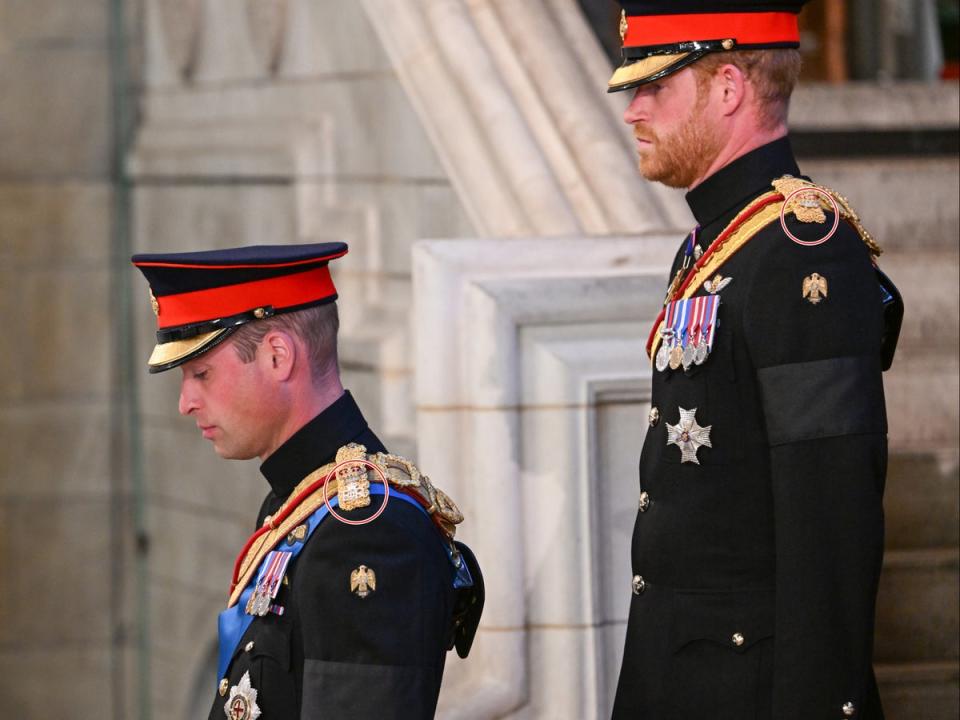 El príncipe Guillermo y el príncipe Harry con el detalle de la inscripción en su uniforme