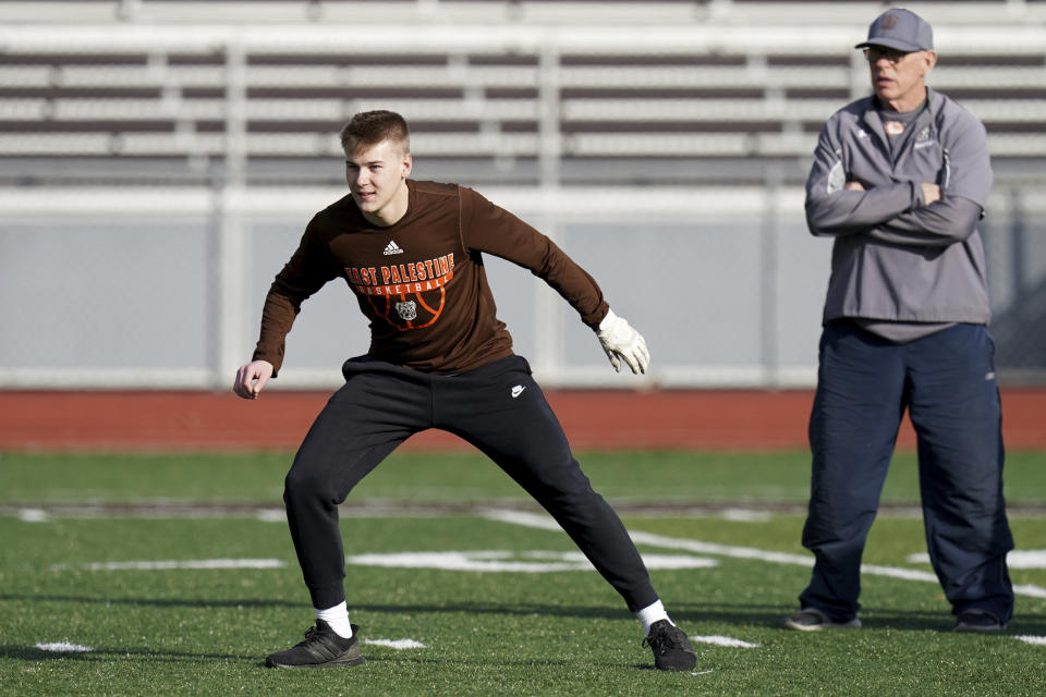 East Palestine High School senior Owen Elliott takes part in baserunning drills next to head coach Bill Sattler, Monday, March 6, 2023, in East Palestine, Ohio. Athletes are navigating spring sports following the Feb. 3 Norfolk Southern freight train derailment. (AP Photo/Matt Freed)