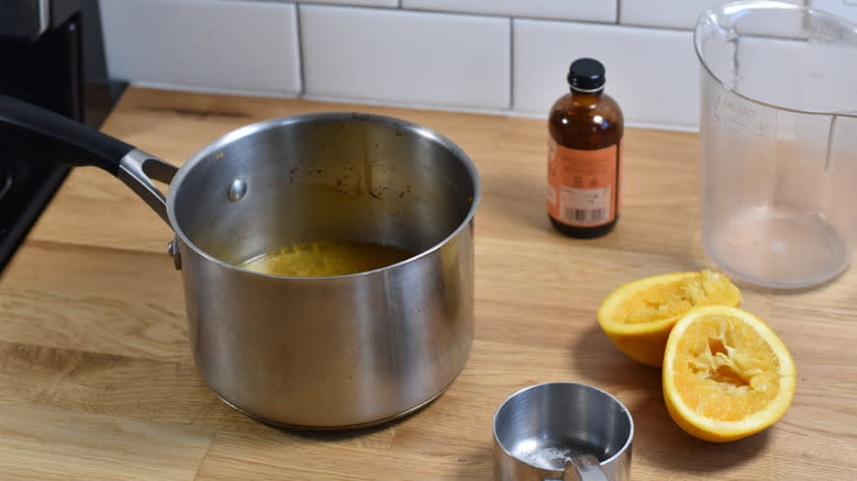 adding orange juice and sugar to pot