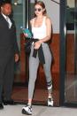 <p>In a white tank top, grey striped leggings, platform sneakers, a black leather handbag, Gentle Monster reflective sunnies and a black sweatshirt wrapped at the waist. </p>