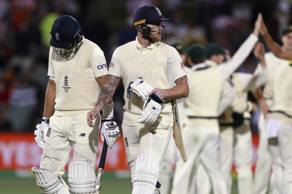 England's Joe Root, left, and Ben Stokes leave the field at stumps on the fourth day of their Ashes cricket test match in Adelaide, Australia, Sunday, Dec. 19, 2021. (AP Photo/James Elsby)