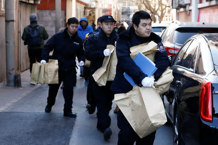 Police carry bags from a primary school that was the scene of a knife attack in Beijing, China, January 8, 2019. REUTERS/Thomas Peter