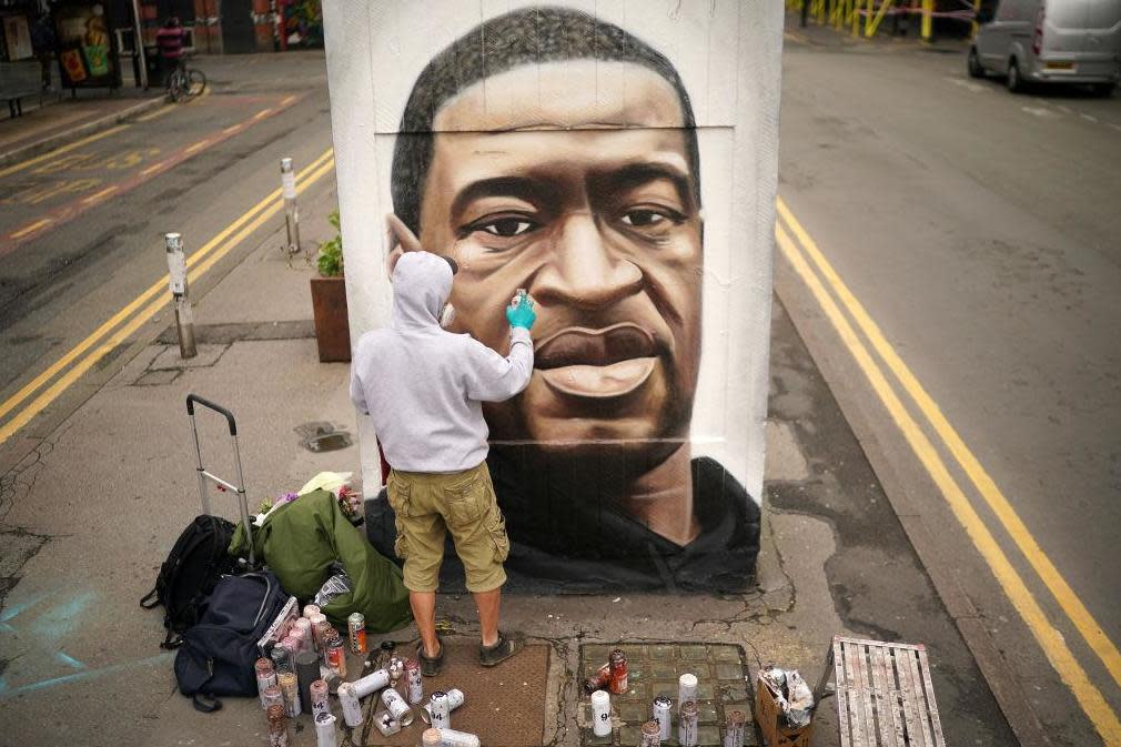 Graffiti artist Akse spray paints the mural of George Floyd in Manchester's northern quarter on June 3: Getty Images