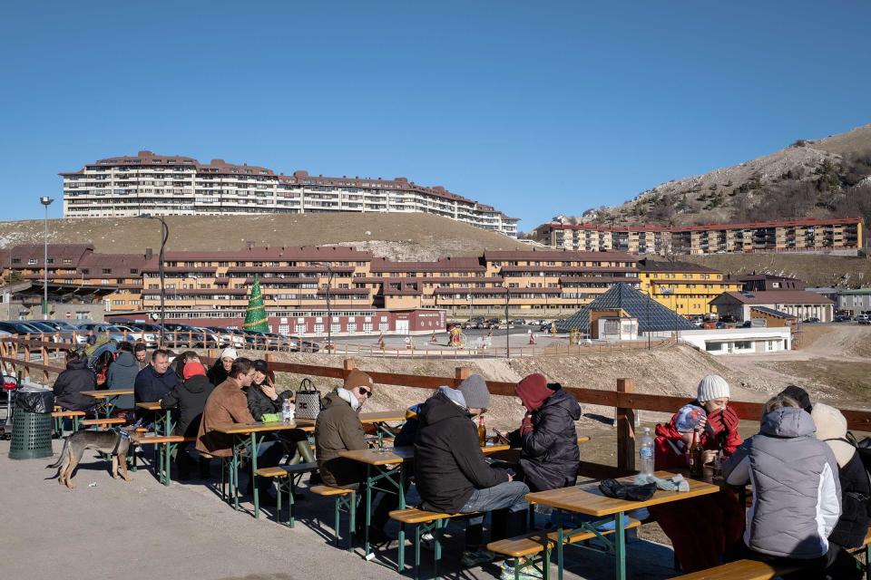 Visitors eat lunch outside the Campitello Matese ski resort where skiing and other winter sports were unavailable in early January 2023.<span class="copyright">Manuel Dorati</span>