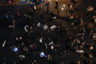 Protesters chant slogans and wave the Israeli national flag during a protest against Israel's Prime Minister Benjamin Netanyahu outside his residence in Jerusalem, Saturday, Oct. 17, 2020. Thousands of Israelis demonstrated outside Netanyahu's official residence for the first time in nearly a month, resuming the weekly protest after emergency restrictions imposed as part of a coronavirus lockdown were lifted. The protesters are demanding Netanyahu's resignation, saying he cannot serve while on trial for corruption charges and accusing him of mismanaging the country's coronavirus crisis. (AP Photo/Ariel Schalit)