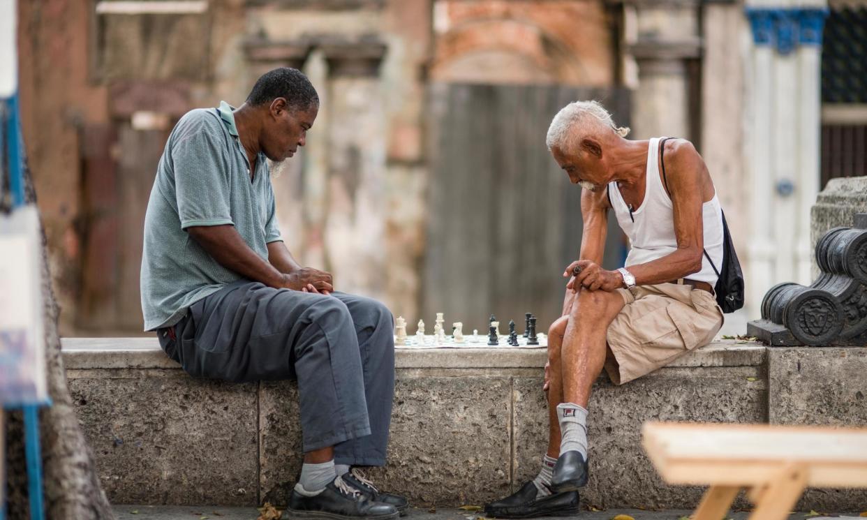 <span>Two older Cubans play chess outdoors in Havana.</span><span>Photograph: Andreana Bitsis/Alamy</span>