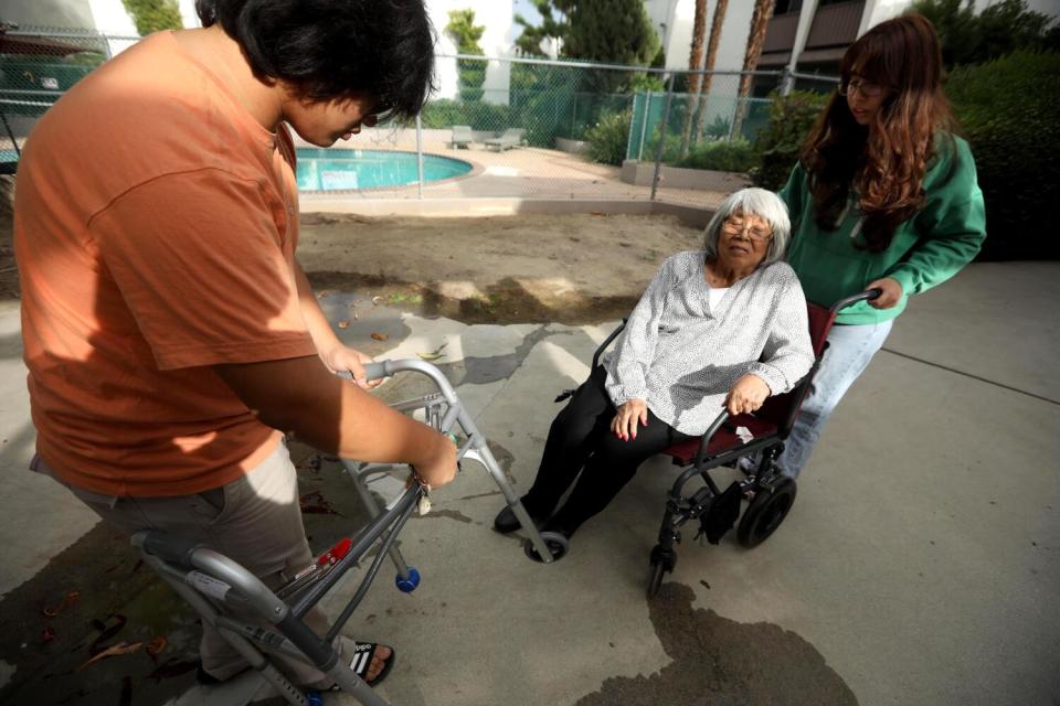 Rosa Angelica Saldana is helped by her grandchildren to their apartment in Northridge.