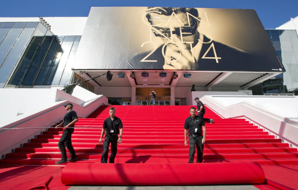 Workers prepare the red carpet on the stairs of the Palais des Festivals prior to the start of the 67th international film festival, Cannes, southern France on Wednesday, May 14, 2014. The festival runs from May 14th to May 25th. (AP Photo/Virginia Mayo)