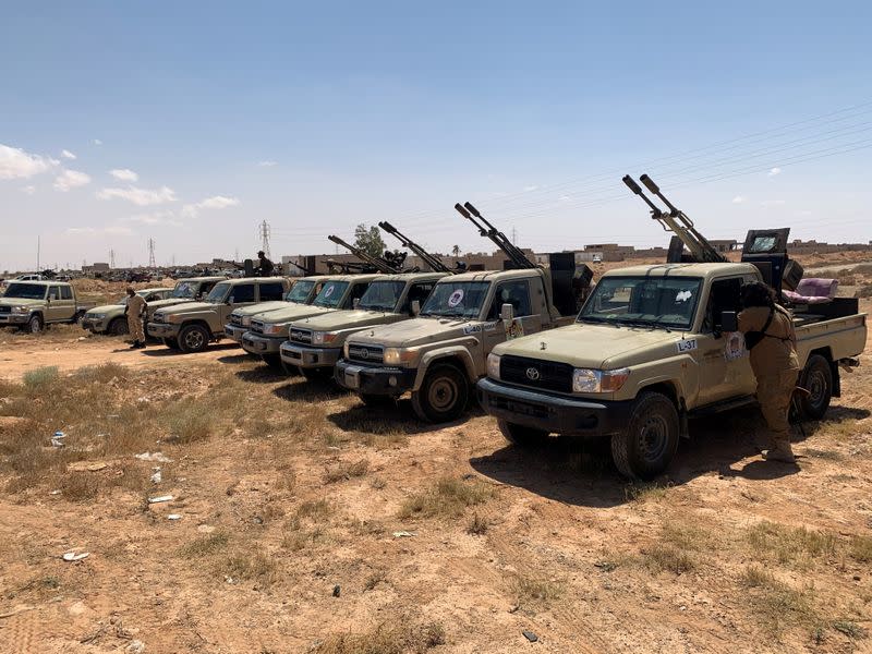 Troops loyal to Libya's internationally recognized government are seen in military vehicles as they prepare before heading to Sirte