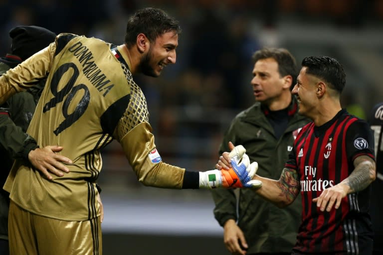 AC Milan's goalkeeper Gianluigi Donnarumma (L) celebrates with AC Milan's forward Giacomo Lapadula after the Italian Serie A football match AC Milan versus Juventus on October 22, 2016