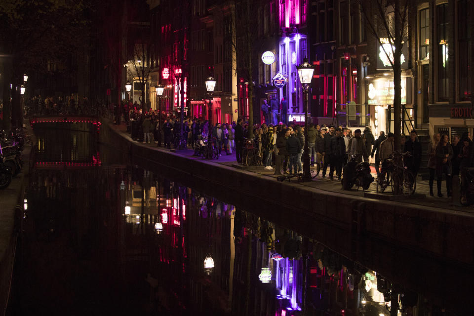 Turistas amontonados en una calle de la zona roja de Ámsterdam junto a un canal el 29 de marzo del 2019. Se junta tanta gente que a veces prácticamente no se puede caminar.  (AP Photo/Peter Dejong)
